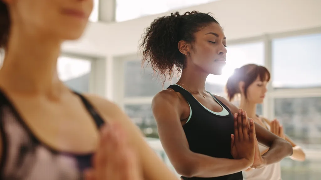 Florida-Woman in yoga studio, zen bright warm glow of sunlight coming in from the windows. New pet-friendly apartment homes for rent with private fenced backyards in Florida with pool, pickleball, dog park, gym, clubhouse and gated community. *No breed or weight restrictions. Yardly